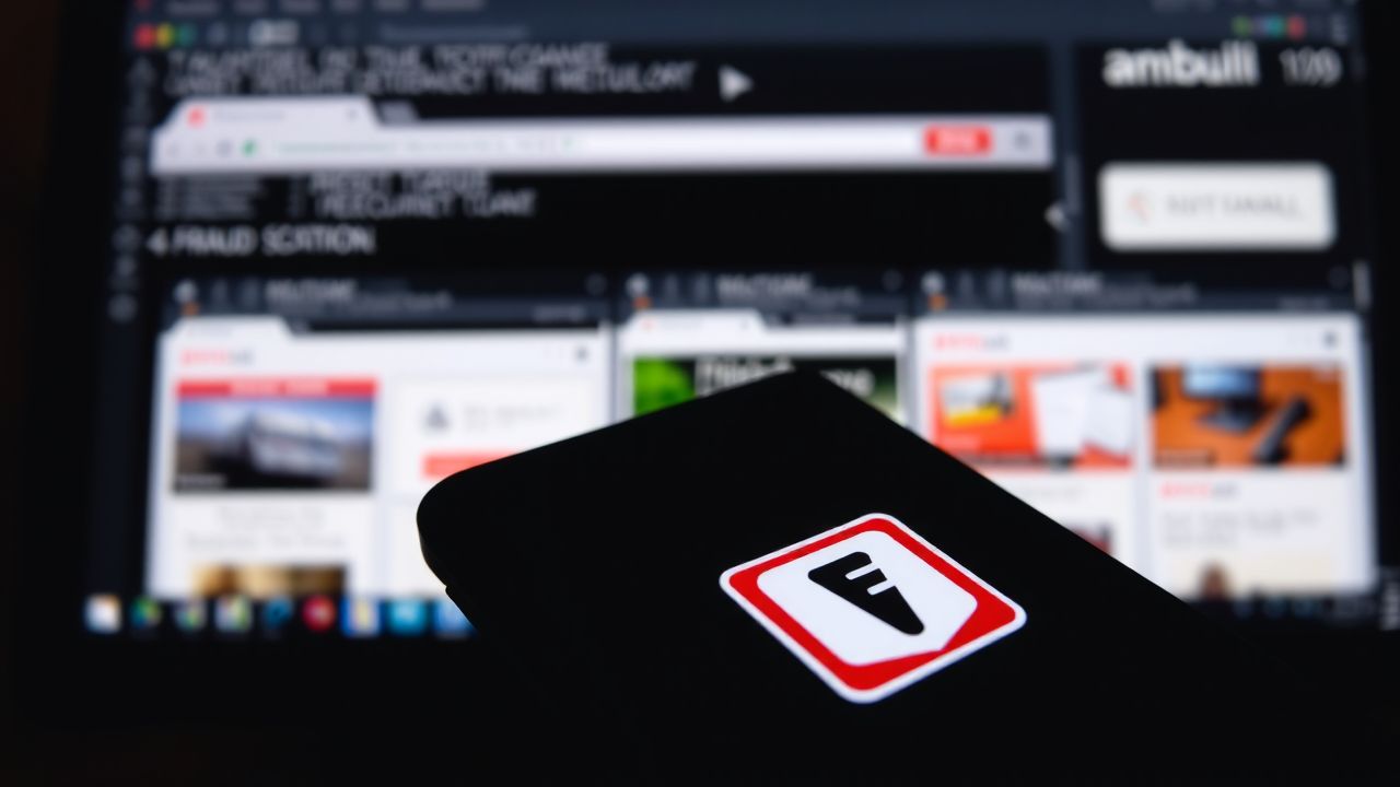 Een close-up van een smartphone met de Fraud Scanner app-logo en een computer met verdachte websites. Een close-up van een smartphone met de Fraud Scanner app-logo en een computer met verdachte websites.